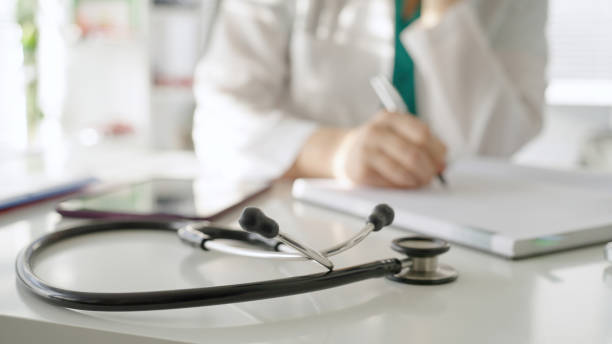 istock Female doctor writing in doctor's office 1446451645