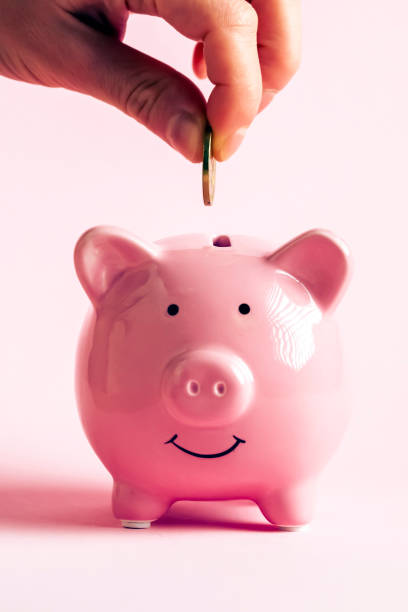 istock Hand puts a coin in a piggy bank. 1446454787