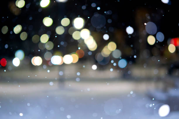Blurred background. City view, lights, falling snow, night, street, bokeh spots