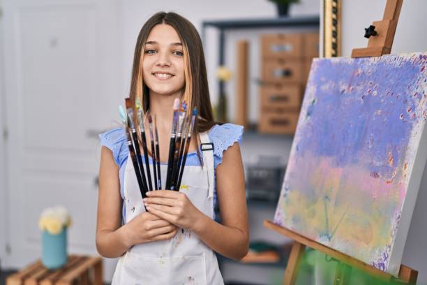 istock Adorable girl smiling confident holding paintbrushes at art studio 1446458168