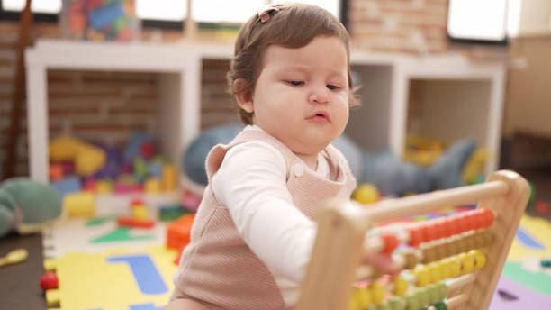 istock Adorable toddler playing with abacus sitting on floor at kindergarten 1446458546