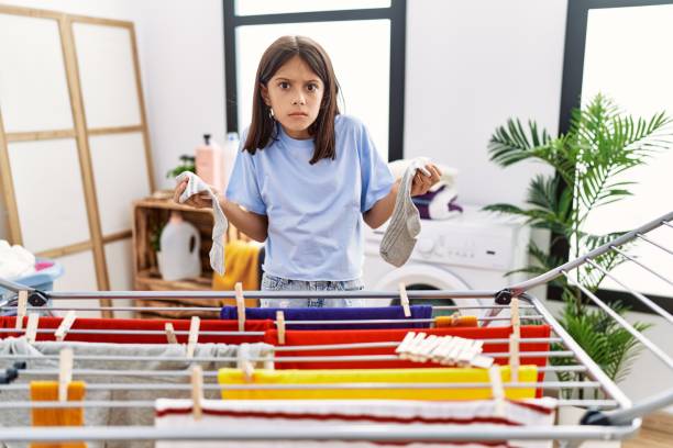 istock Young hispanic girl hanging socks on clothline clueless and confused expression. doubt concept. 1446458671