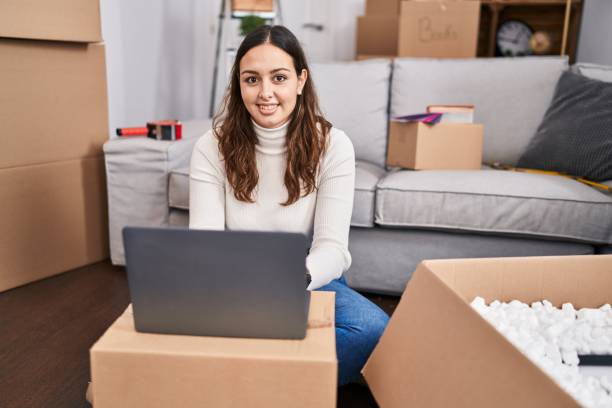 istock Young beautiful hispanic woman smiling confident using laptop at new home 1446458949