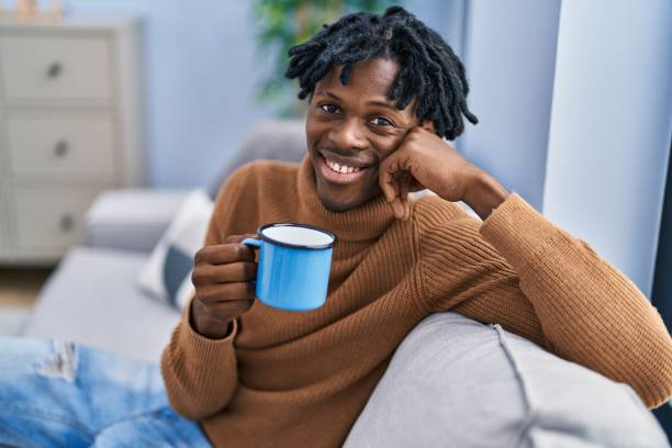 istock African american man drinking coffee sitting on sofa at home 1446459527