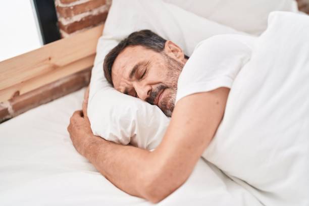 istock Middle age man lying on bed sleeping at bedroom 1446459569