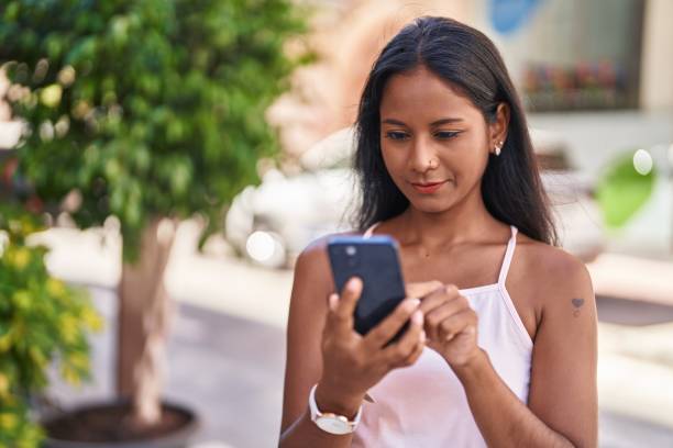 istock Young beautiful woman smiling confident using smartphone at street 1446459879
