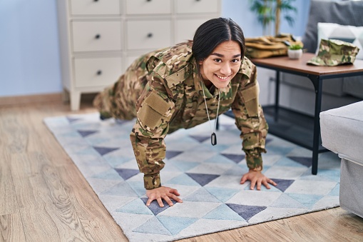 Young hispanic woman army soldier training at home