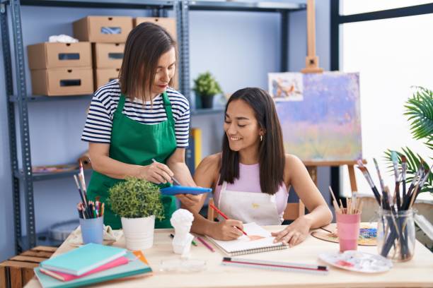 istock Two women artists using touchpad drawing on notebook at art studio 1446460163