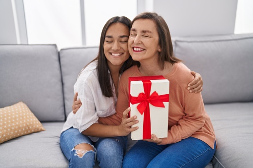 Two women mother and daughter surprise with gift at home