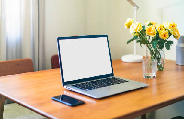 istock A laptop and flowers on a wooden table 1446462766