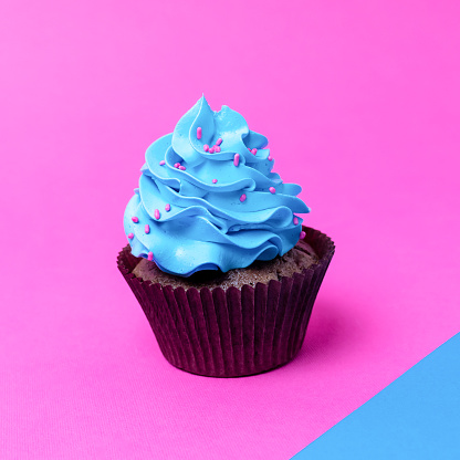 Birthday cupcake on pink and blue background