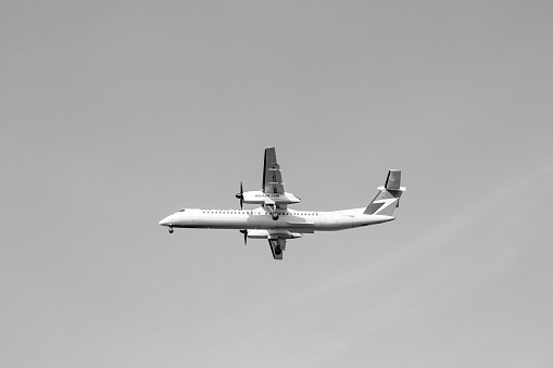 Vancouver, BC, Canada- October 13, 2022: WestJet airlines a Canadian low- cost airline plane jet flying into Vancouver International Airport (YVR) in black and white