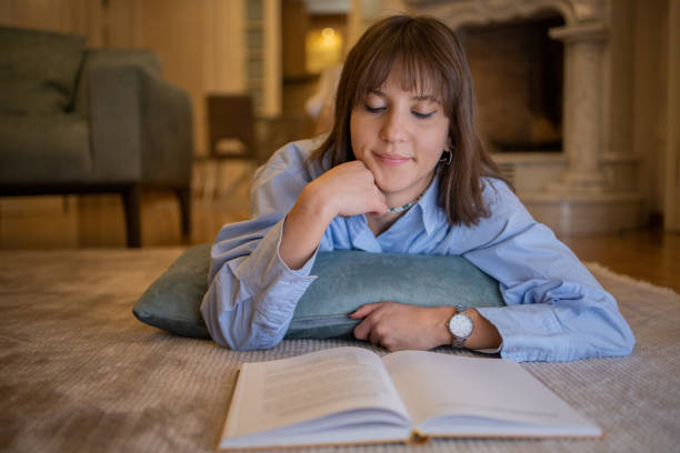 istock Happy woman reading book at home 1446465729
