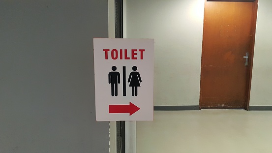 Toilet or restroom sign board with brown door background