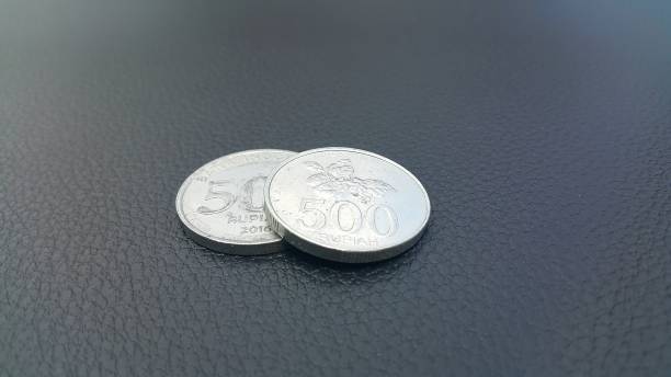 zbliżenie dwóch monet na teksturowanym czarnym materiale - cash register old coin wealth zdjęcia i obrazy z banku zdjęć