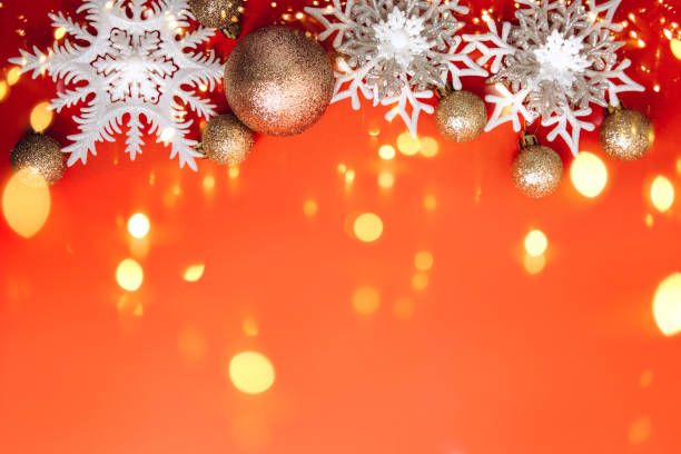 Christmas decorations, white snowflakes and golden balls, on a red background with lights stock photo