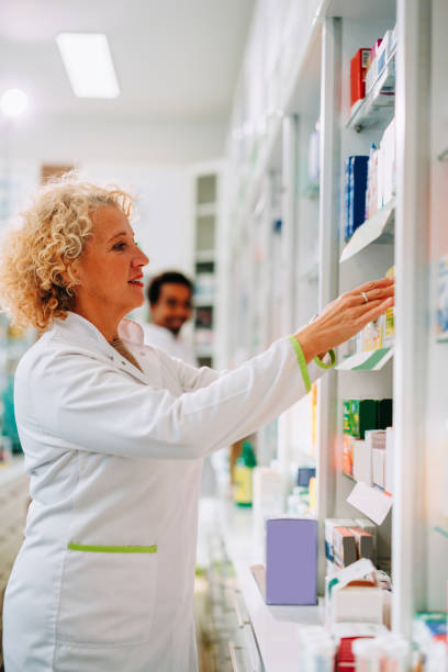 istock Senior pharmacist restocking shelves. 1446475792