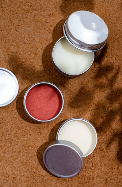istock colorful lip balms in round tin cases on leather with shadow overlay, mockup design 1446476961