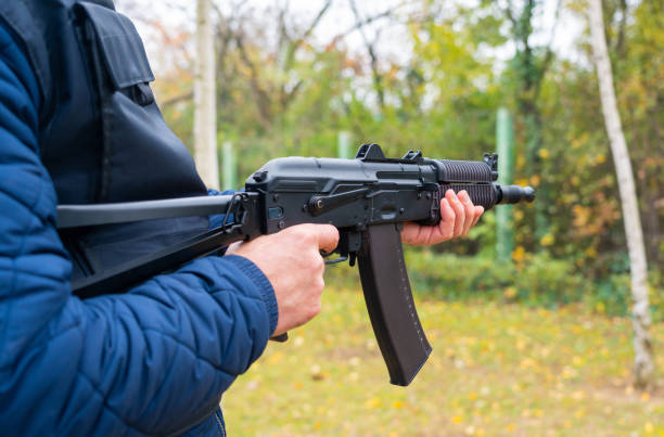 istock A man holds a machine gun for shooting from the hip 1446477894