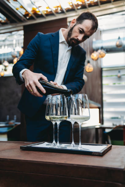 istock A waiter is pouring prosecco into glasses at the restaurant 1446478719