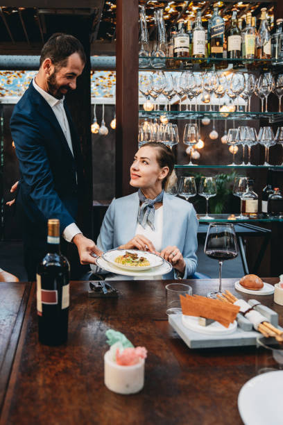 A waiter is serving food in an high-end restaurant