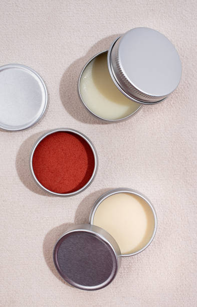 istock colorful lip balms in round tin cases on leather background with shadow overlay, mockup design 1446479163