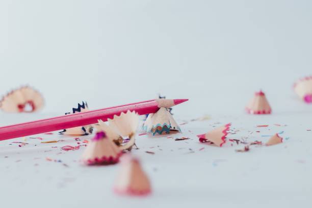 istock Closeup of a sharpened pink pencil with pencil shavings on white surface 1446479307