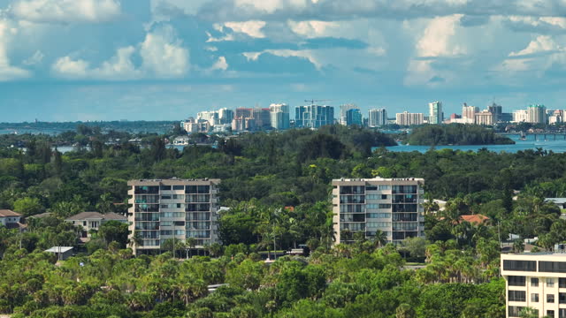High angle point of view of american Sarasota city in Florida, USA. Distant downtown with high skyscrapers and office buildings on horizon and green suburbs with hotels in front