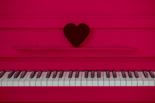 the concept of Valentine's day. The black heart is on the pinkpiano