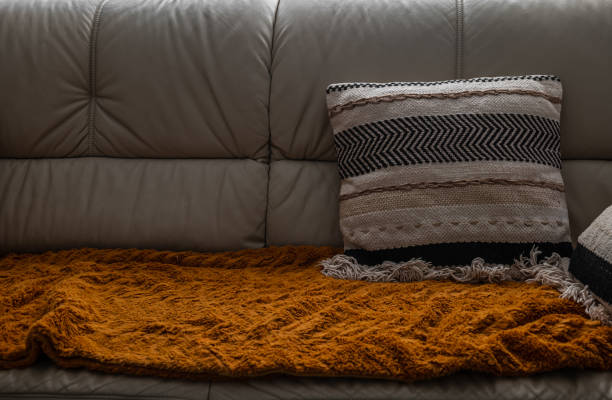 White leather sofa with orange pillow