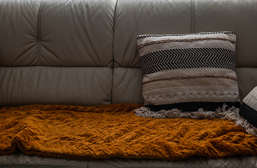 close up of a sofa with a blanket and a pillow. interior background with a sofa. vintage decoration
