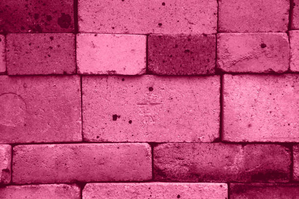 Viva magenta background of old textured bricks of different shades. Texture stock photo