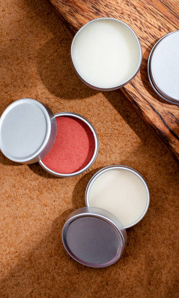 istock colorful lip balms in round tin cases on leather with shadow overlay, mockup design 1446482342