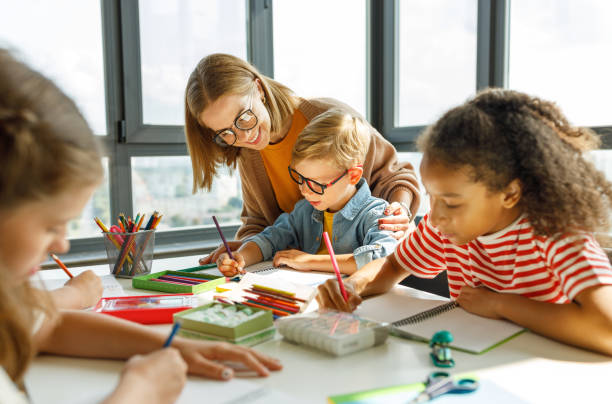 istock Teacher helping children with schoolwork 1446483160