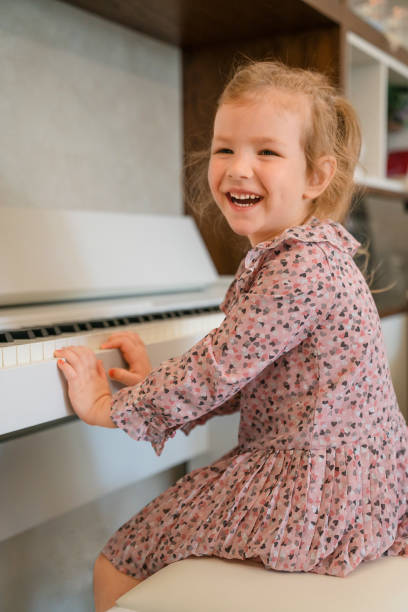 istock Adorable kid playing piano at home 1446486399