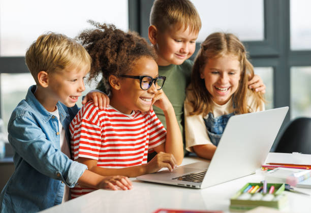istock Cheerful  schoolkids   looking at laptop screen during online lesson 1446488622