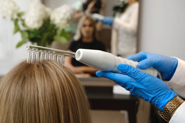 istock Doctor making hair treatment using Darsonval apparatus at trichologist 1446491199