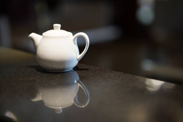 istock White teapot for brewing tea on a black stock photo 1446492433
