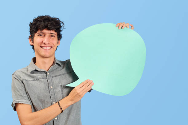 istock Charismatic young man with dialogue bubble on blank in blue flat lay. 1446494833
