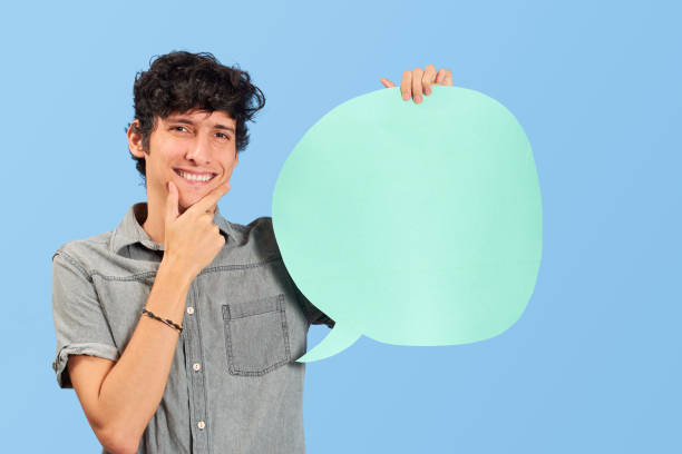 istock Charismatic young man with dialogue bubble on blank in blue flat lay. 1446494838