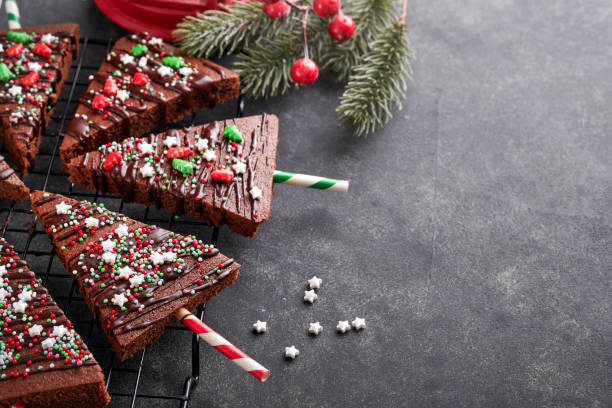 istock Chocolate brownies Christmas tree with chocolate icing and festive sprinkles on stone table. Christmas food ideas sweet homemade Christmas holidays pastry concept. Holiday cooking concept. Top view. 1446495074