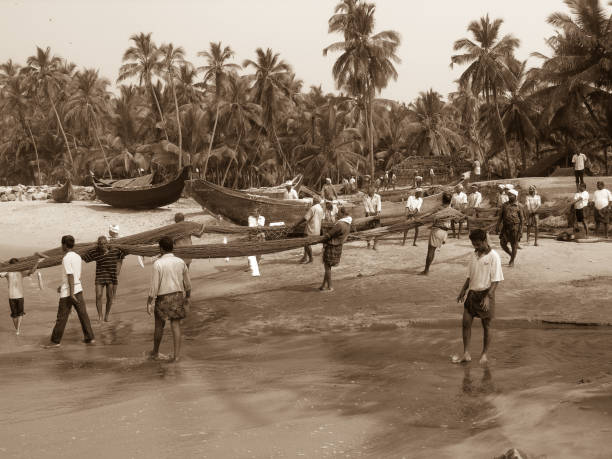 Varkala, Kerala, India - nov 19, 2005: retro style shot of a group of fishermen retrieve their fishing net on a beach near Varkala, Kerala, South India.