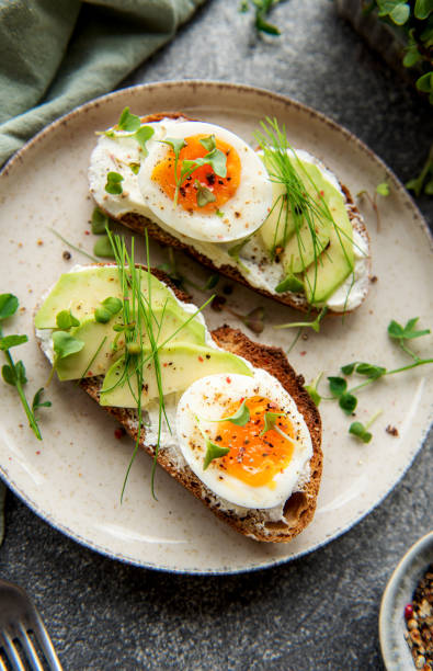 istock Bread toast, boiled eggs, avocado slice, microgreens on a plate 1446500642