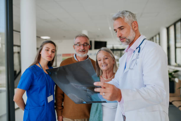 istock Doctor showing x-ray image to patients, explaining diagnosis. 1446502120