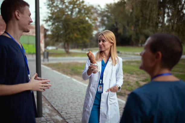 istock The doctor is eating a sandwich while talking to two interns 1446502689