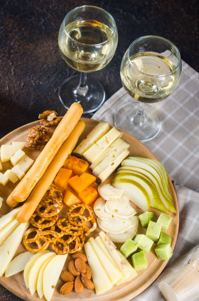 istock Cheese plates served with grapes, jam, snacks, crackers and nuts on a wooden board. 1446505317