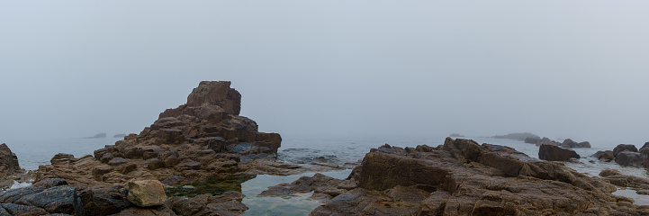 Panorama of rock formation at the sea in the fog on a hazy mystic autumn morning in Sillon de Talbert area, Brittany, France