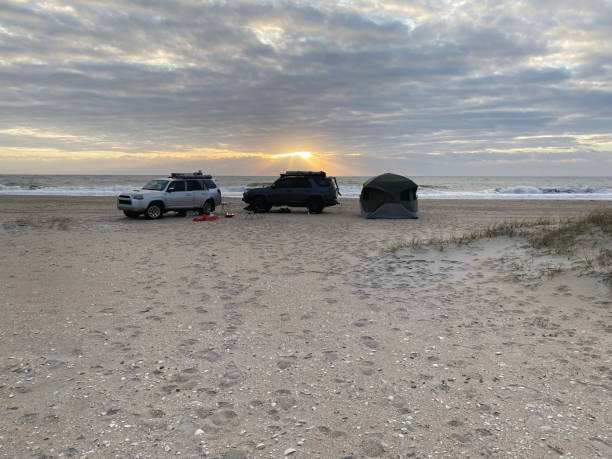 istock Sun rays over overlanding campsite at beach 1446508417