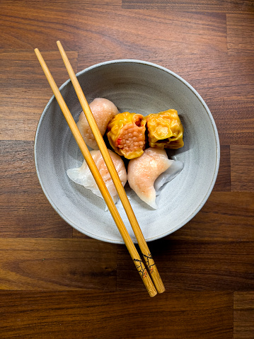 chinese dim sum, in a bowl on a wooden background
