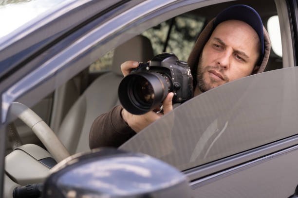 istock Private detective with camera spying from car, taking photo with professional camera 1446510507